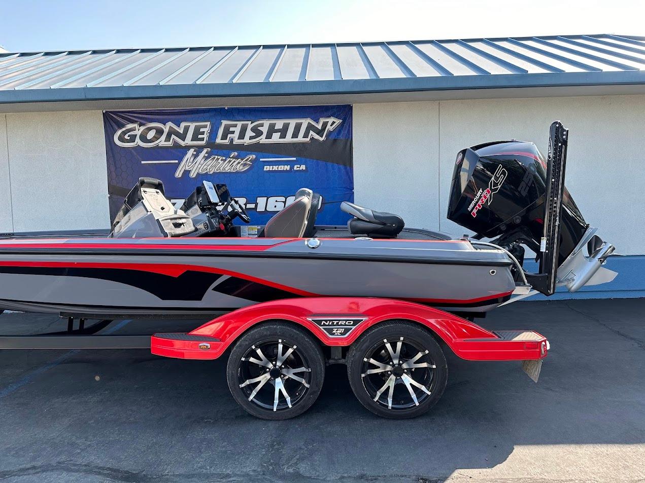 2023 Nitro Z21 XL Pro boat with red accents and trailer, displayed outdoors.