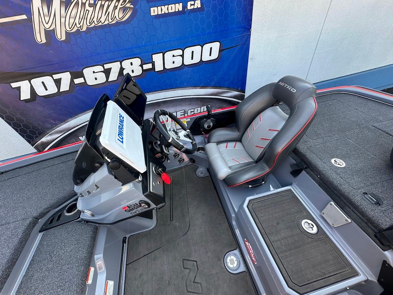 2023 Nitro Z21 XL Pro boat cockpit with steering wheel and seat, displayed at a marine dealership.