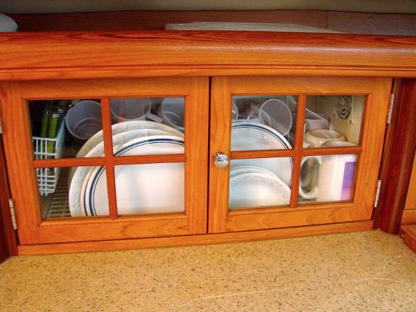Wooden cabinet with dishes in Hunter 44 Deck Salon, 2007 model.