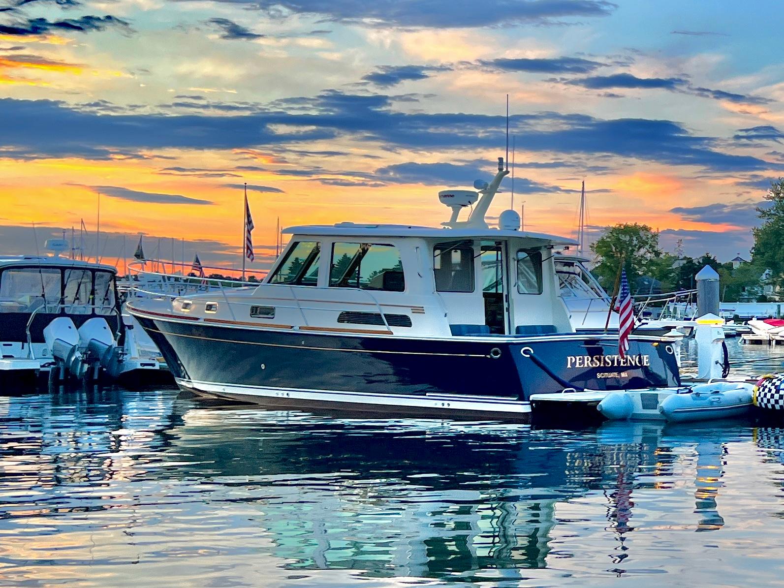 2011 Sabre 40 Sedan yacht docked at sunset, reflecting on calm water.