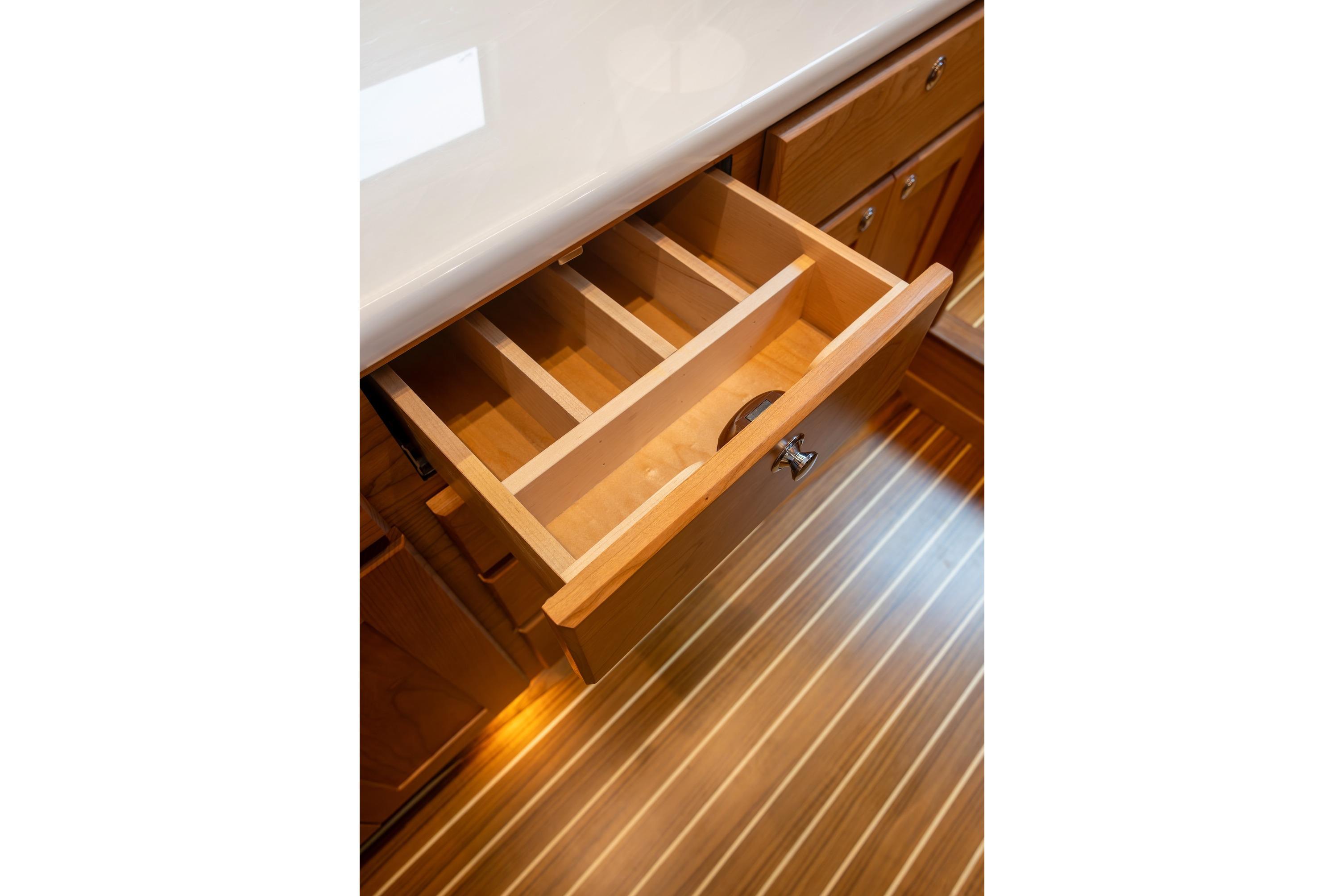 Open wooden drawer with dividers in 2027 Sabre 51 Salon Express yacht interior.
