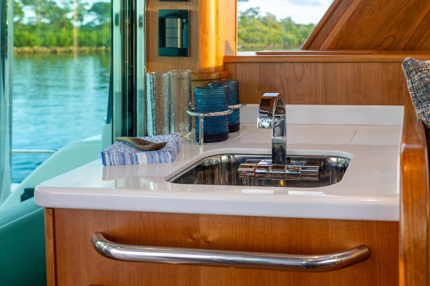 Luxurious interior of 2027 Sabre 51 Salon Express yacht with modern sink and wooden finish.