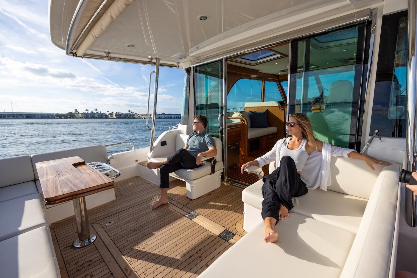 2027 Sabre 51 Salon Express yacht interior with people relaxing on deck.