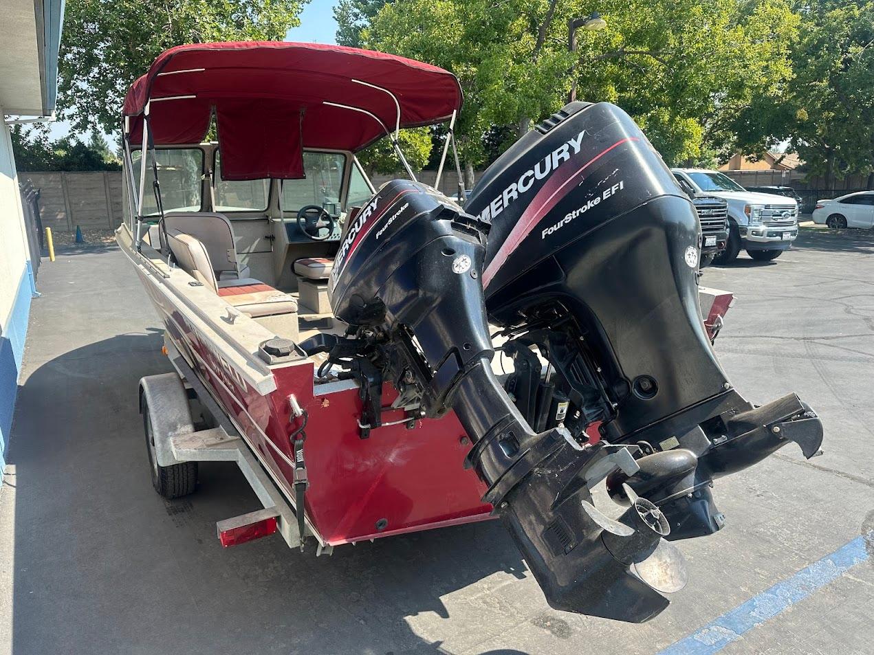 2003 Alumaweld Stryker boat with Mercury outboard motors, parked outdoors.