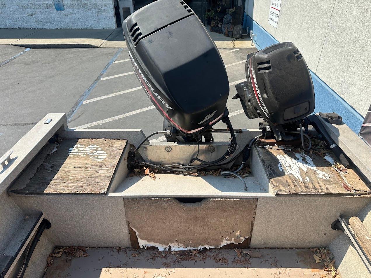 2003 Alumaweld Stryker boat with dual outboard motors, showing wear and weathered surfaces.