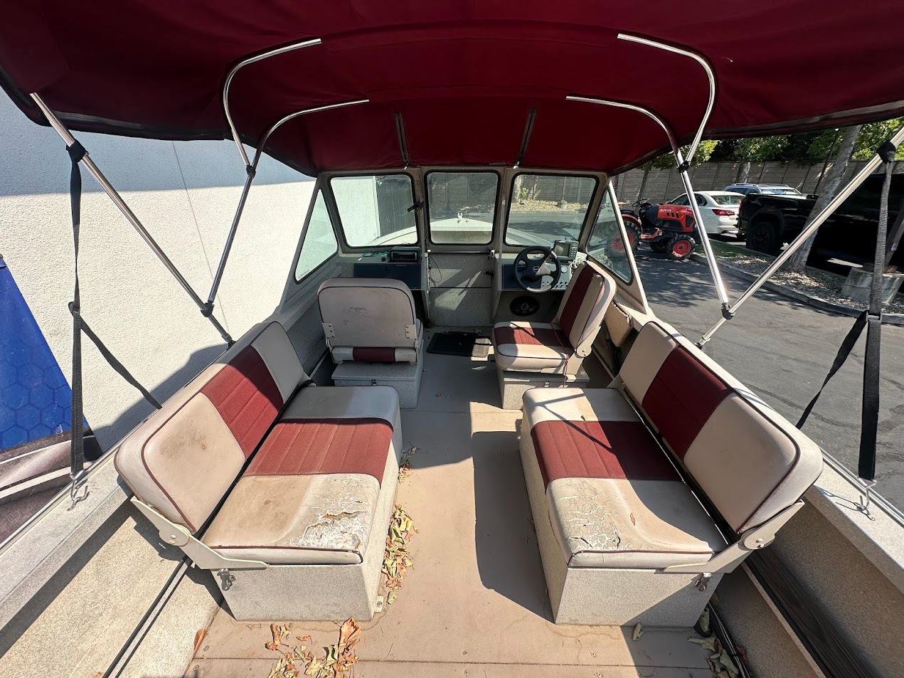 2003 Alumaweld Stryker boat interior with red and beige seating under a canopy.