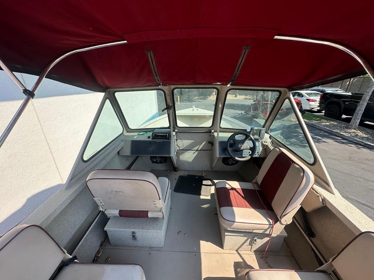 2003 Alumaweld Stryker boat interior with red canopy and seating.