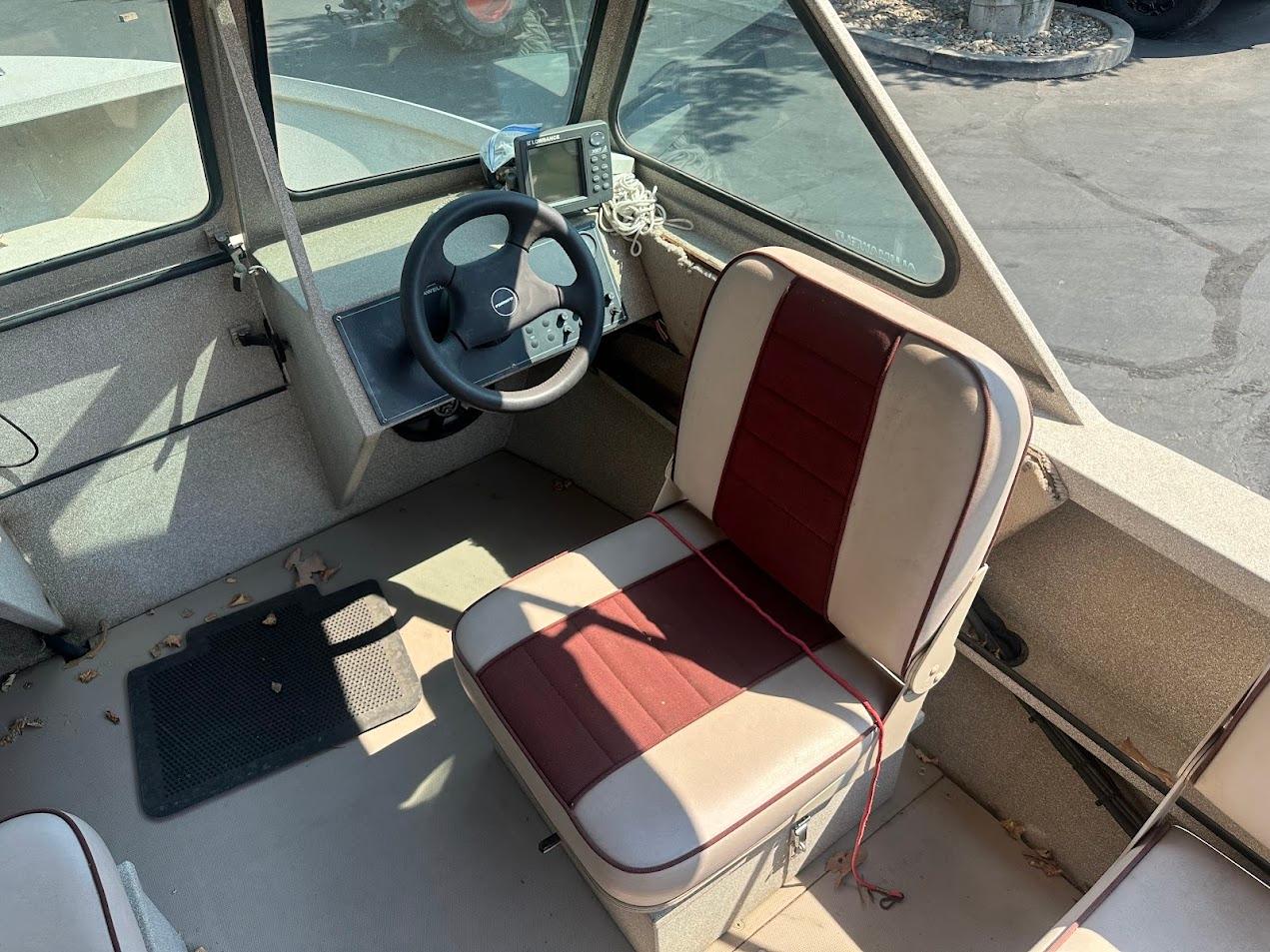 2003 Alumaweld Stryker boat interior with steering wheel and cushioned seat.