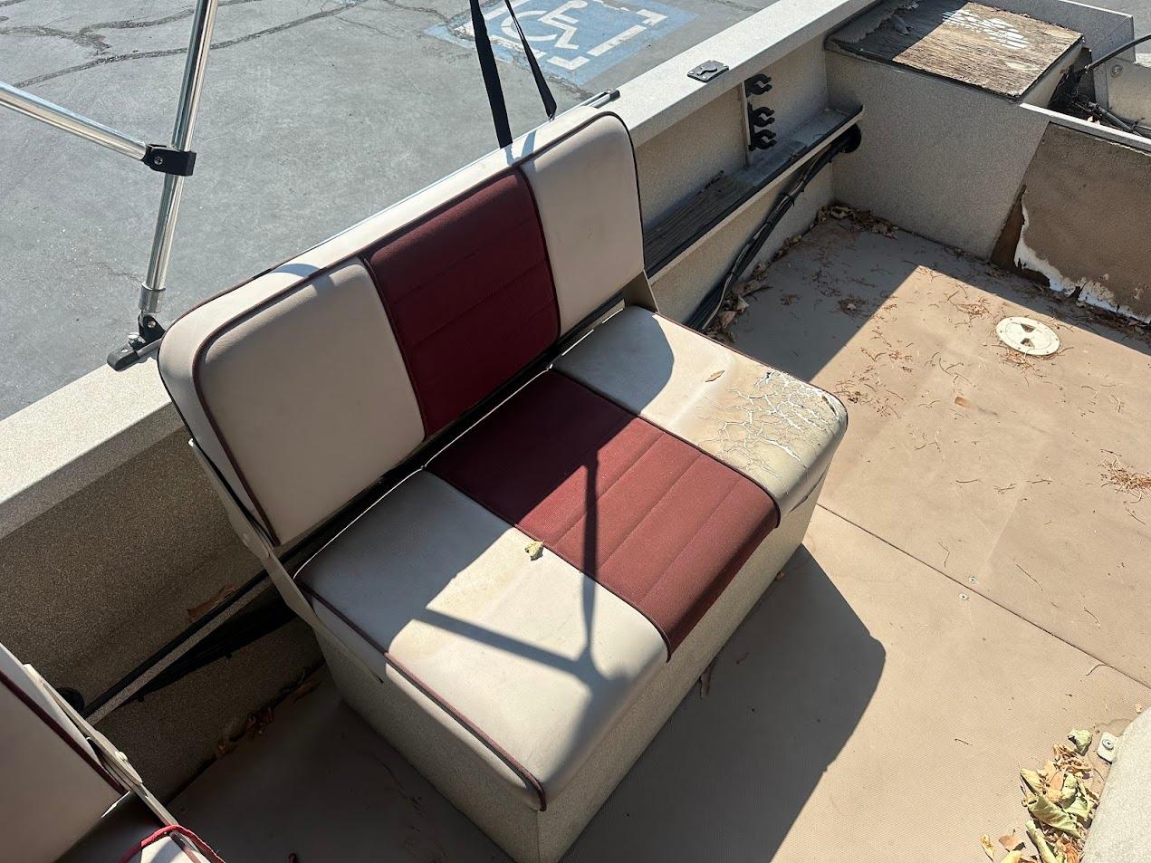 2003 Alumaweld Stryker boat seat with red and beige upholstery, showing signs of wear.