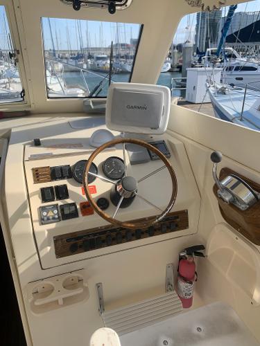 2004 Mainship Pilot 30-II Sedan helm with Garmin GPS, docked in marina.