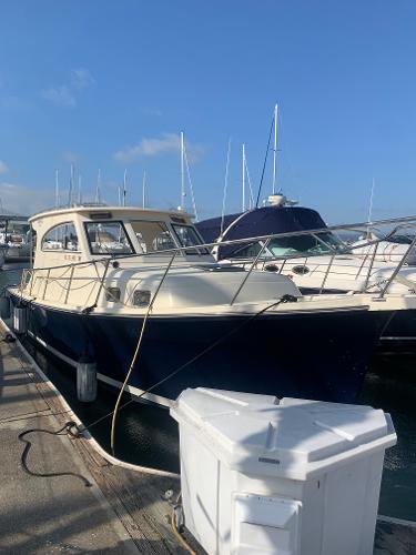 2004 Mainship Pilot 30-II Sedan docked at marina under clear blue sky.