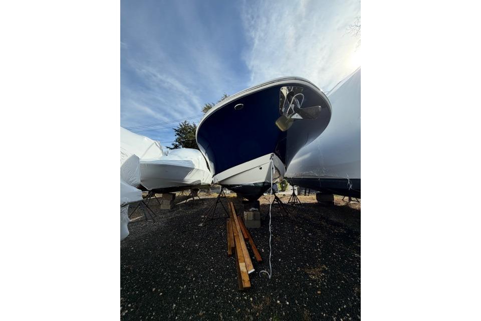2022 Robalo R272 Center Console boat on stands, under a clear blue sky.