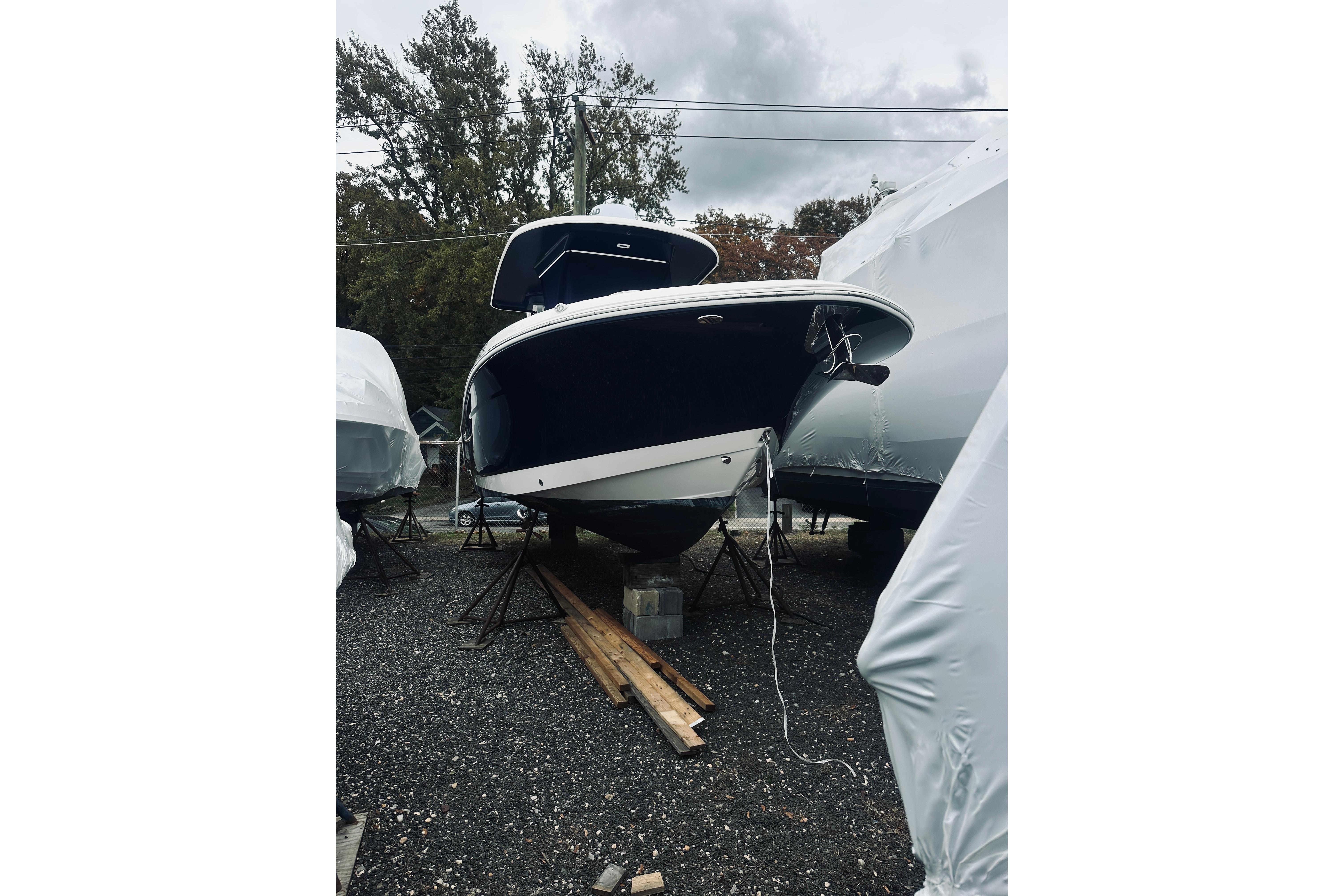 2022 Robalo R272 Center Console boat on stands, surrounded by covered boats.