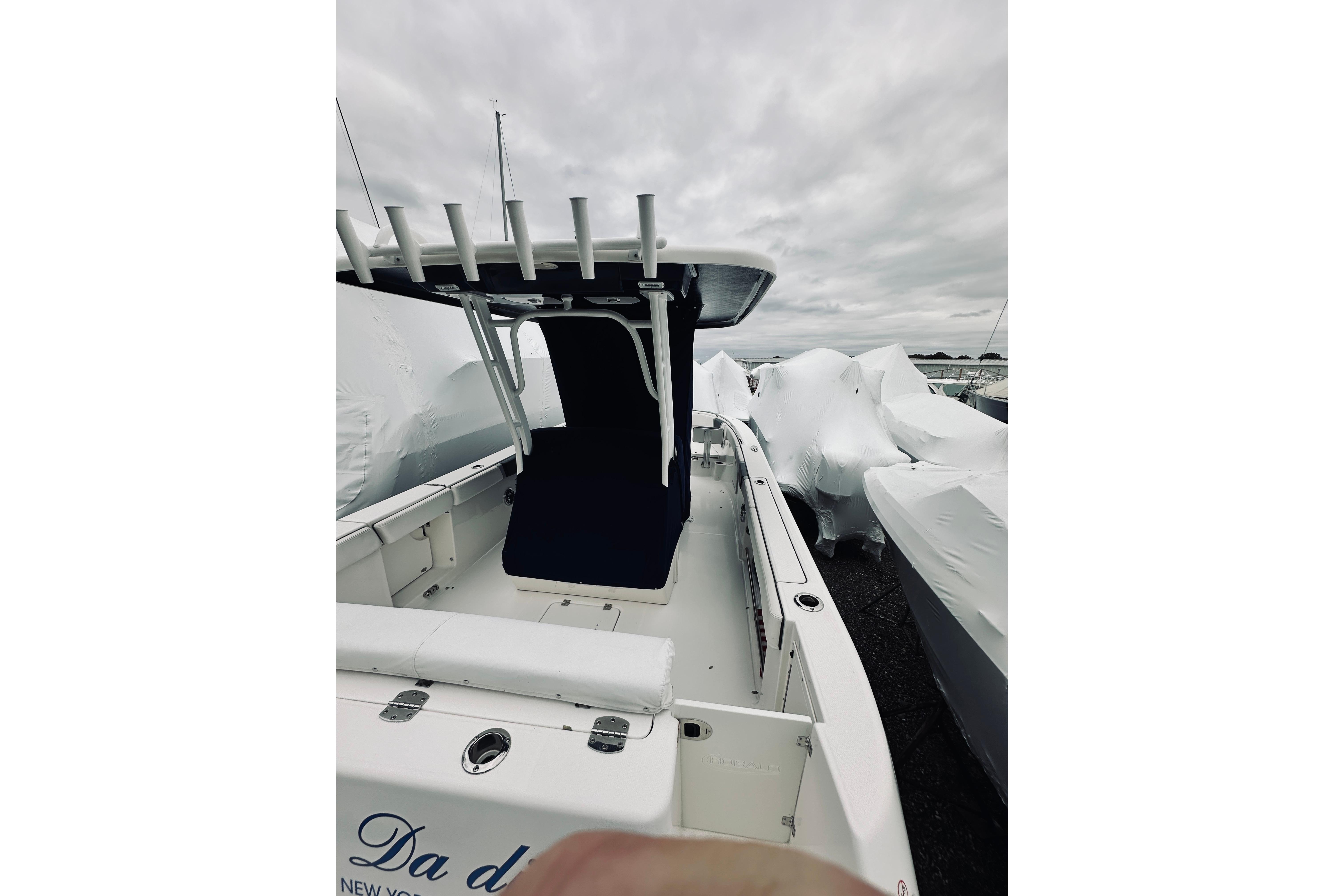 2022 Robalo R272 Center Console boat with covered seating, docked under cloudy skies.
