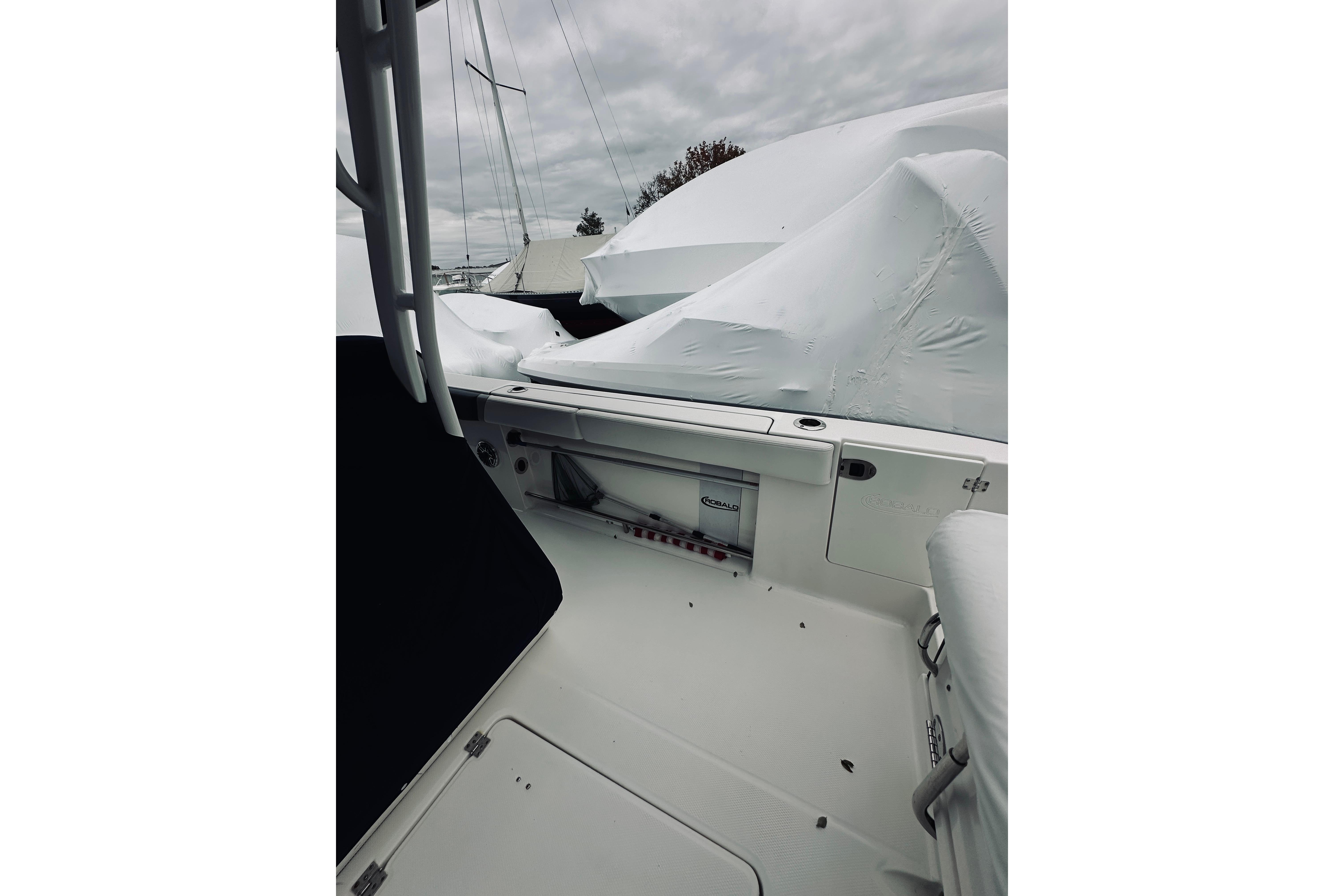 2022 Robalo R272 Center Console boat interior, covered and docked under cloudy skies.