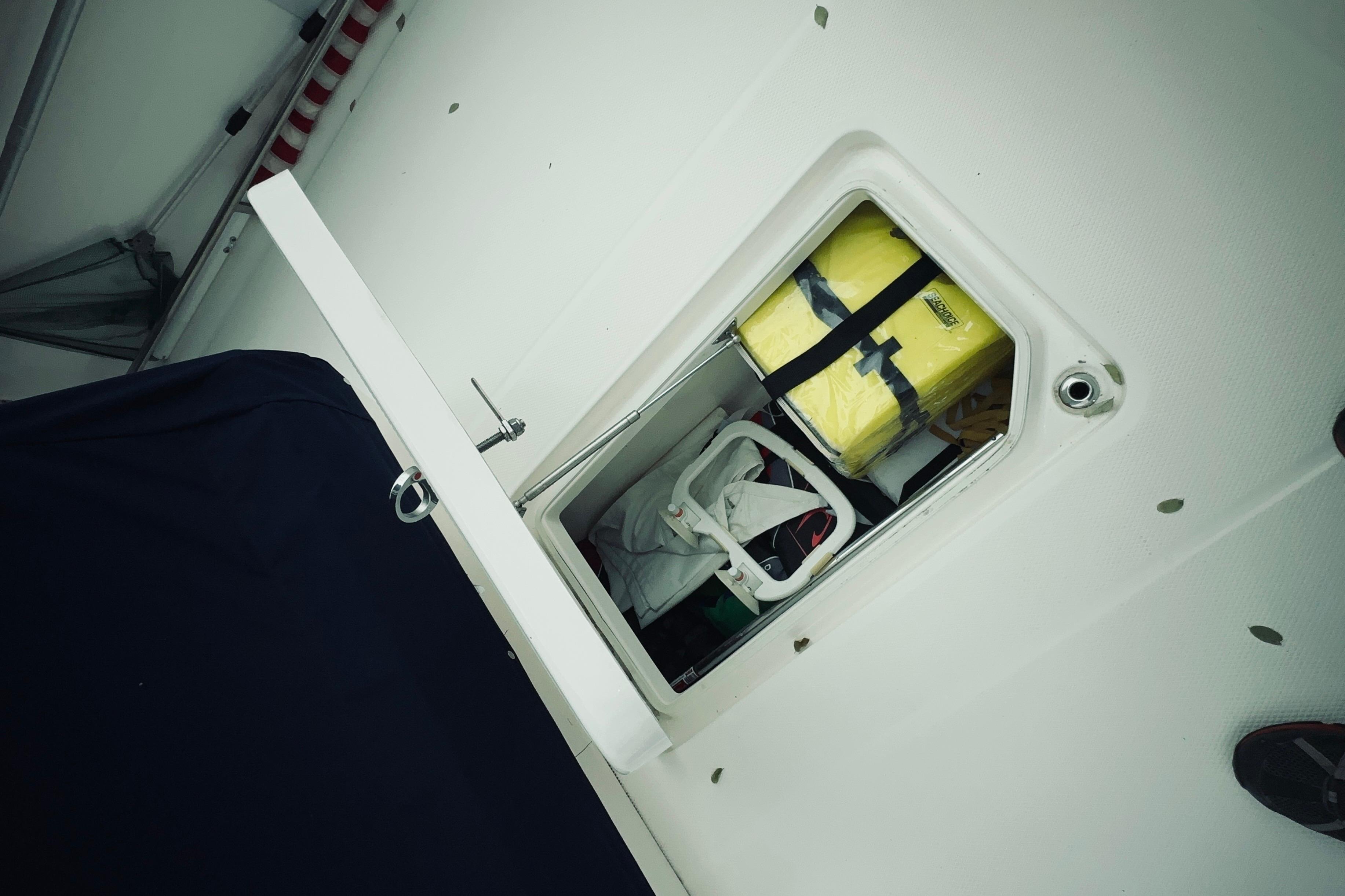 Storage compartment on 2022 Robalo R272 Center Console boat, containing safety equipment.