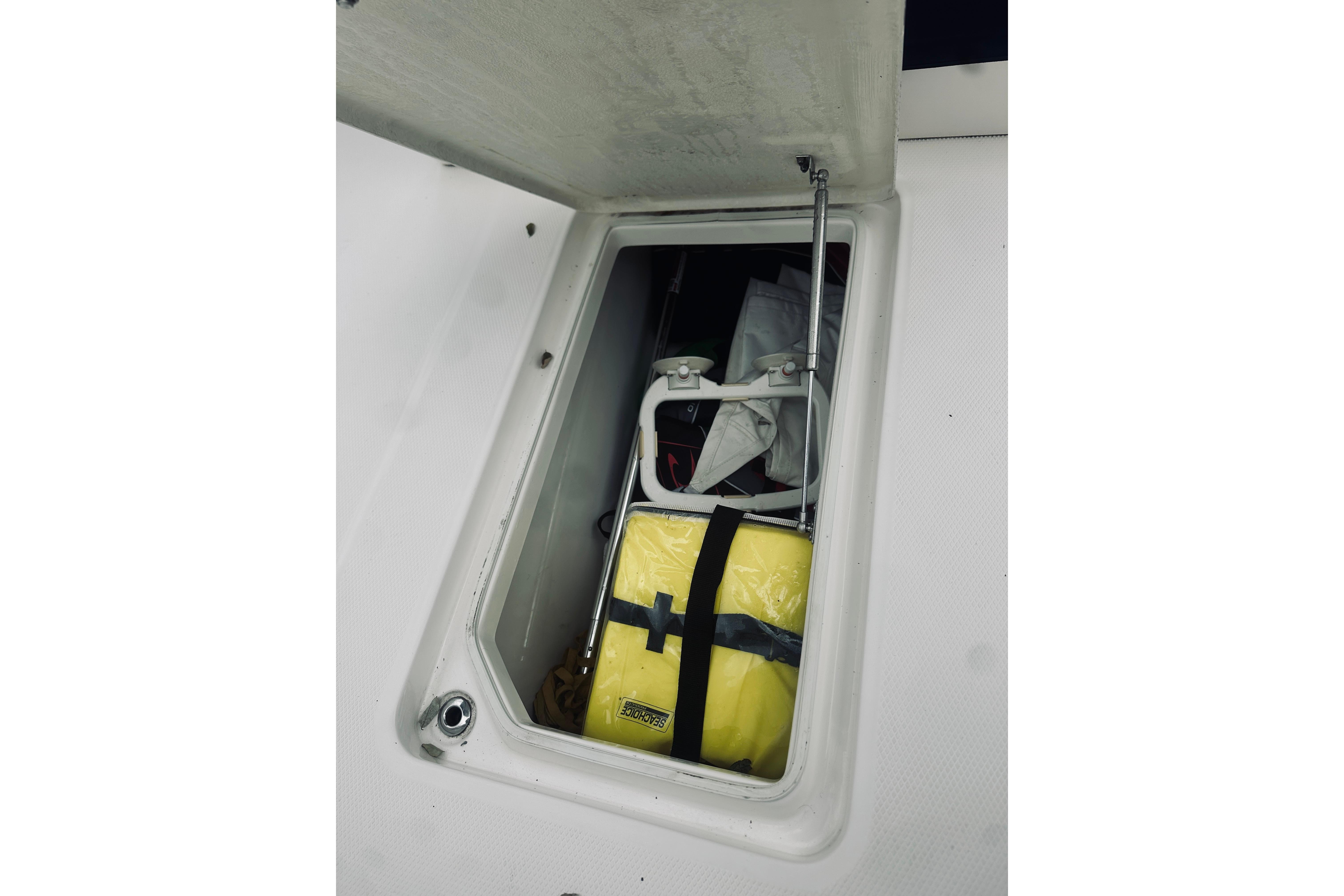 Storage compartment on 2022 Robalo R272 Center Console boat with safety equipment.
