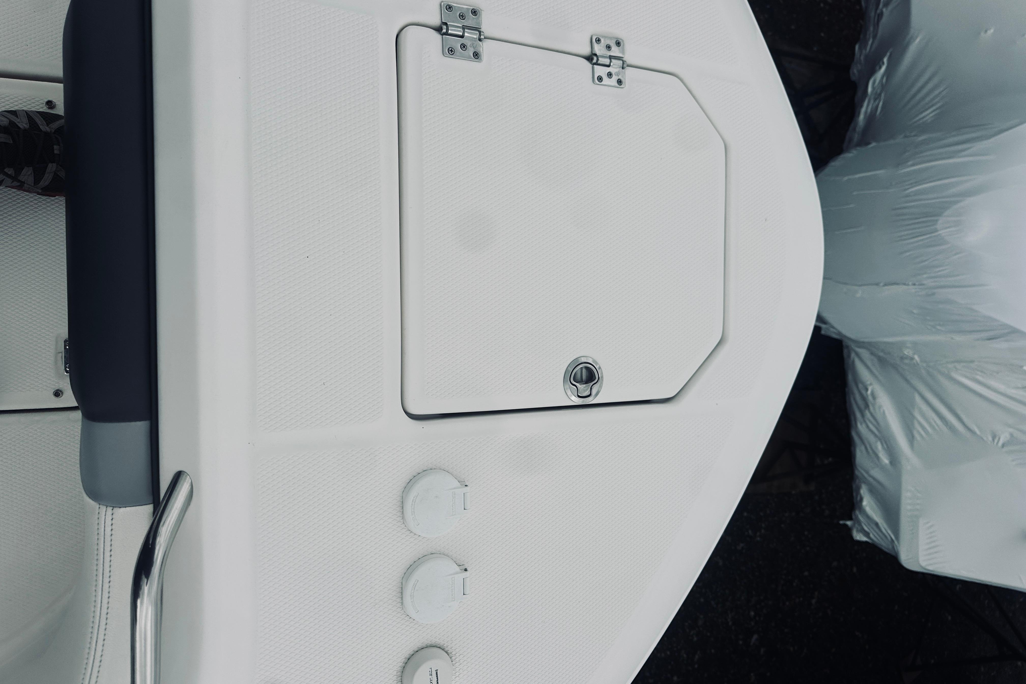 2022 Robalo R272 Center Console boat deck with storage hatch and controls.