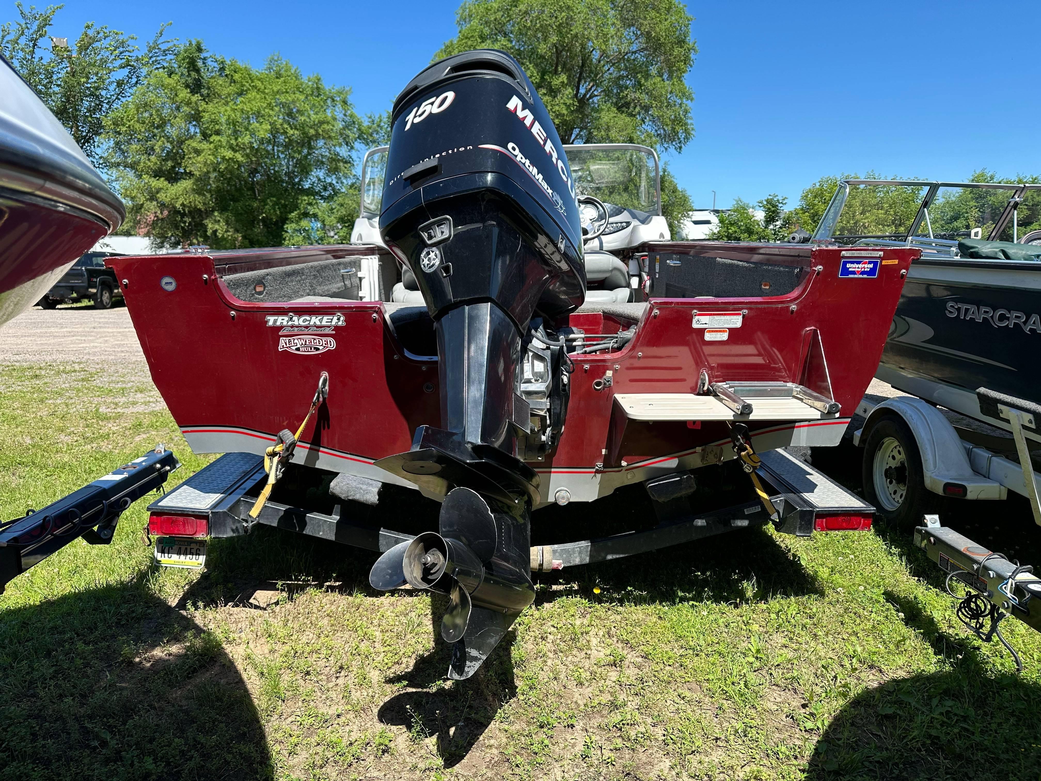2011 Tracker Targa V-18 Combo boat with Mercury 150 engine, parked on grass.