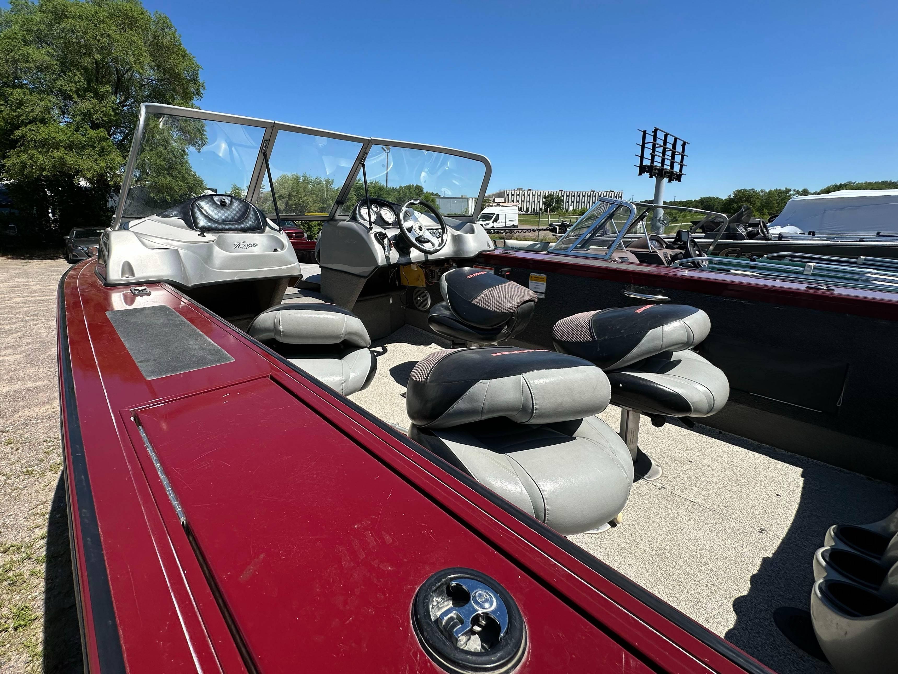 2011 Tracker Targa V-18 Combo boat with seating, steering wheel, and windshield, parked outdoors.