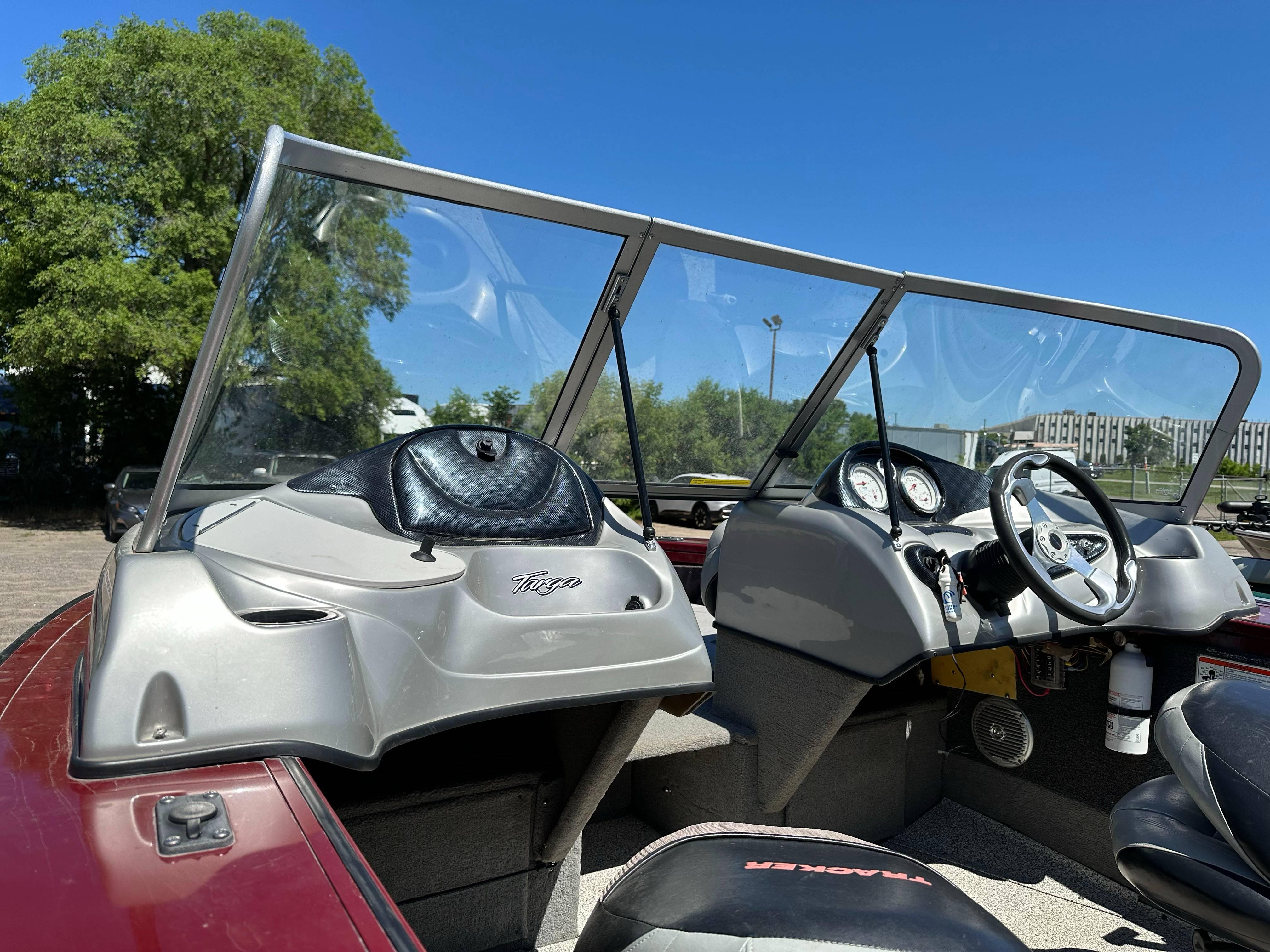 2011 Tracker Targa V-18 Combo boat interior with steering wheel and dashboard under clear blue sky.