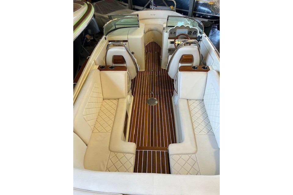2021 Chris-Craft Launch 27 interior with elegant white seating and wooden flooring.