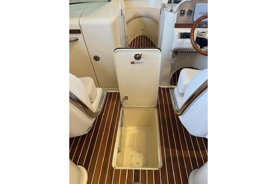 2021 Chris-Craft Launch 27 interior with open storage compartment and elegant wood flooring.