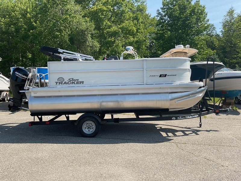 2026 Sun Tracker PB 16 DLX pontoon boat on trailer, parked outdoors.