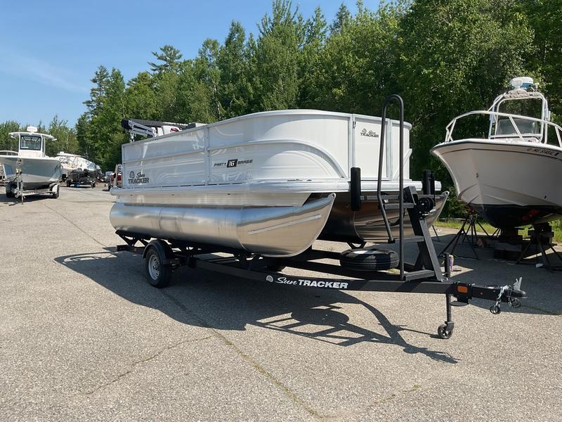 2026 Sun Tracker PB 16 DLX pontoon boat on trailer, parked outdoors.