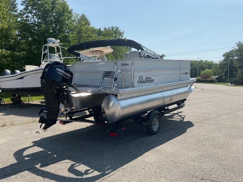 2026 Sun Tracker PB 16 DLX pontoon boat on trailer, parked outdoors.