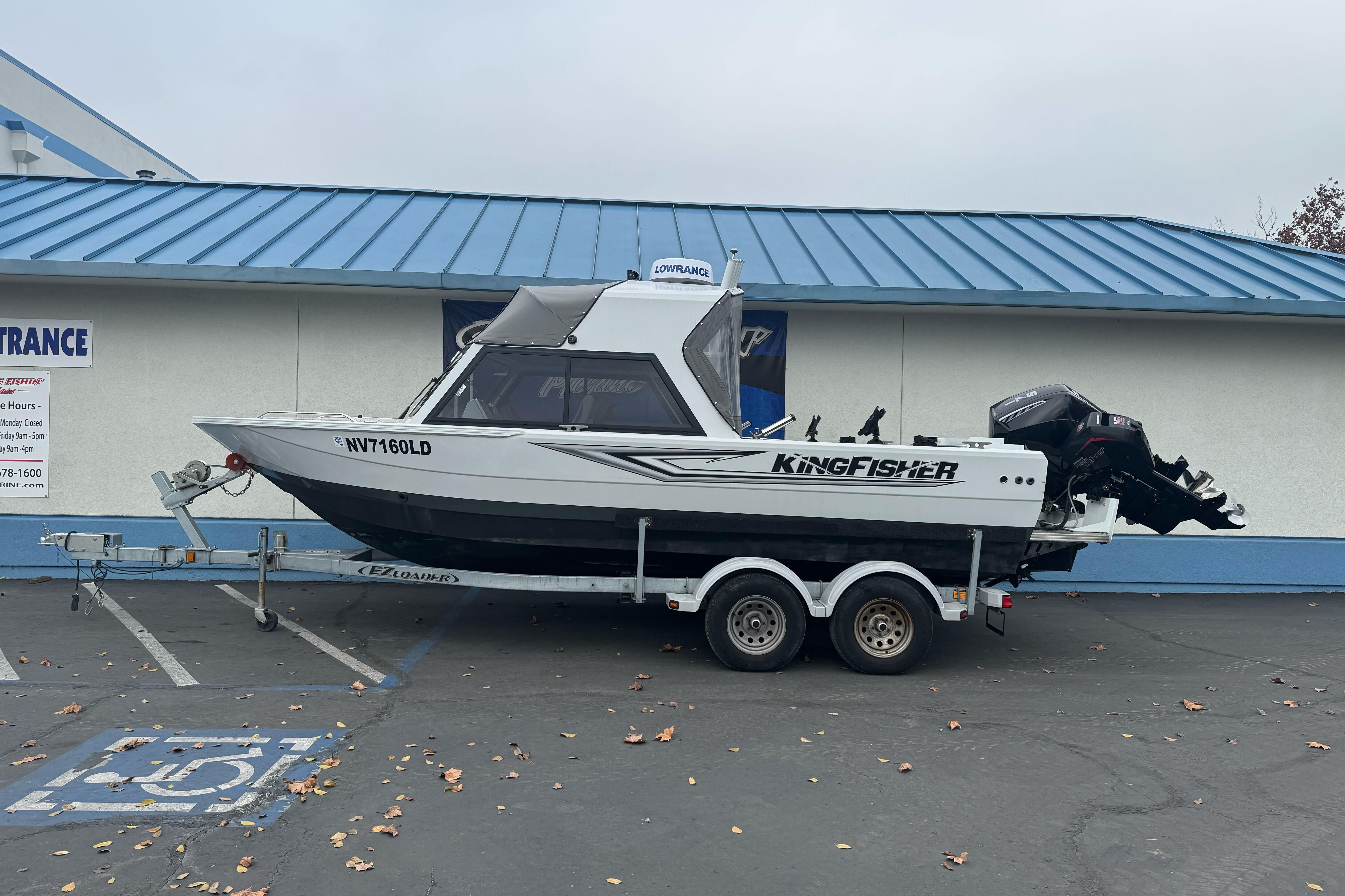 KingFisher 2025 Escape HHT boat on trailer, parked outside building, 2021 model.