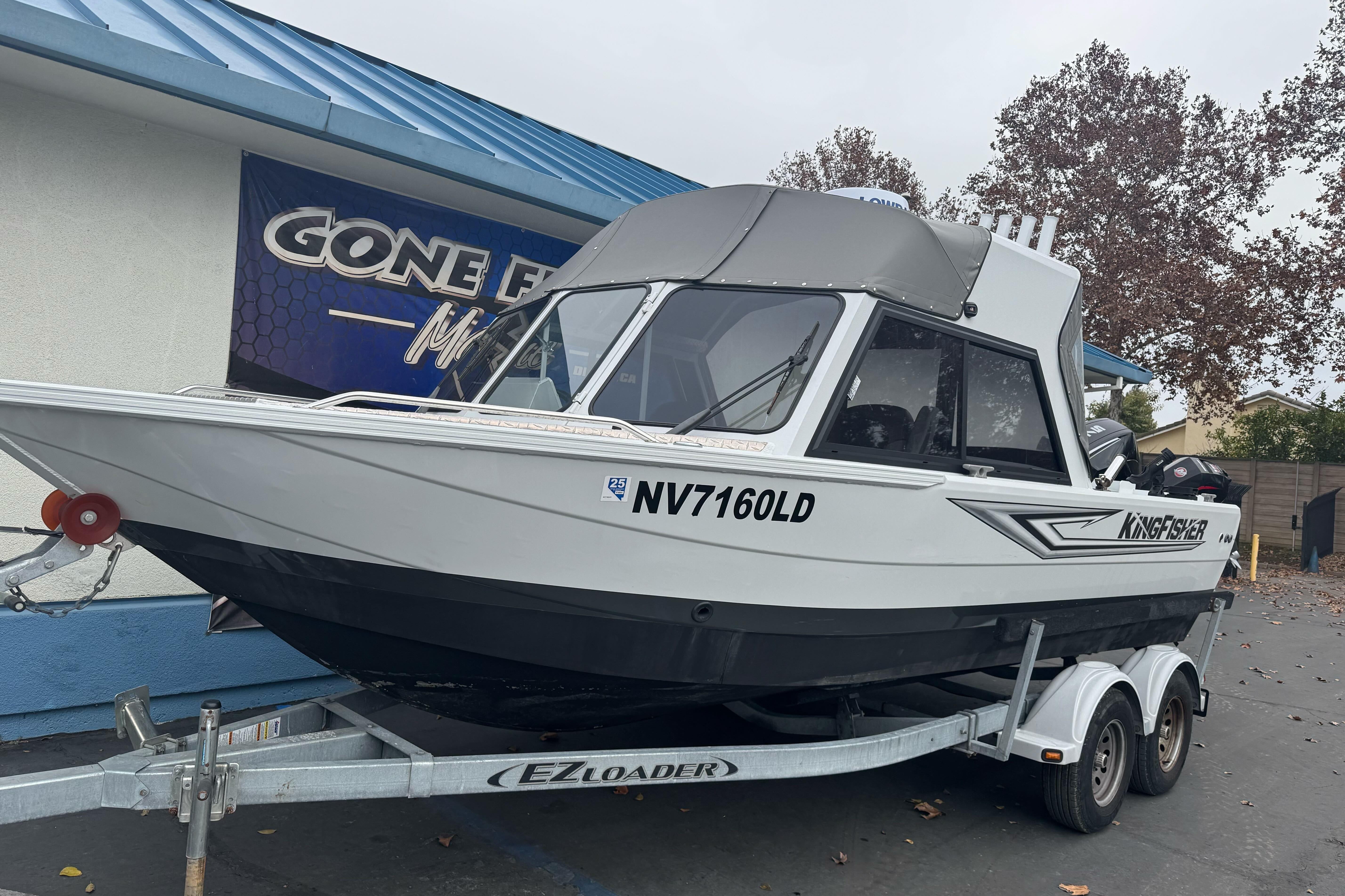 2021 KingFisher 2025 Escape HHT boat on trailer, parked outdoors.
