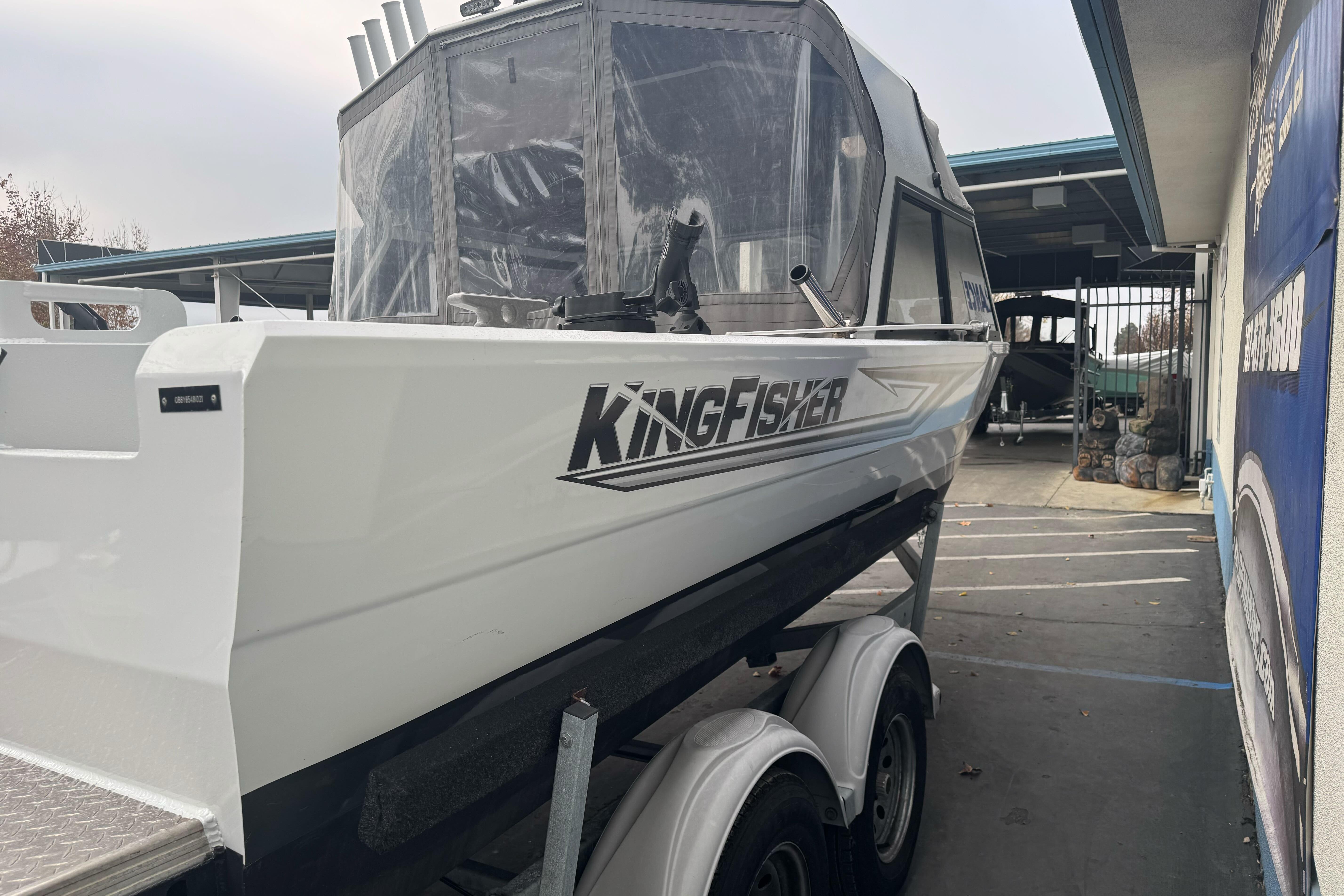 KingFisher 2025 Escape HHT boat on trailer, side view, parked outdoors.