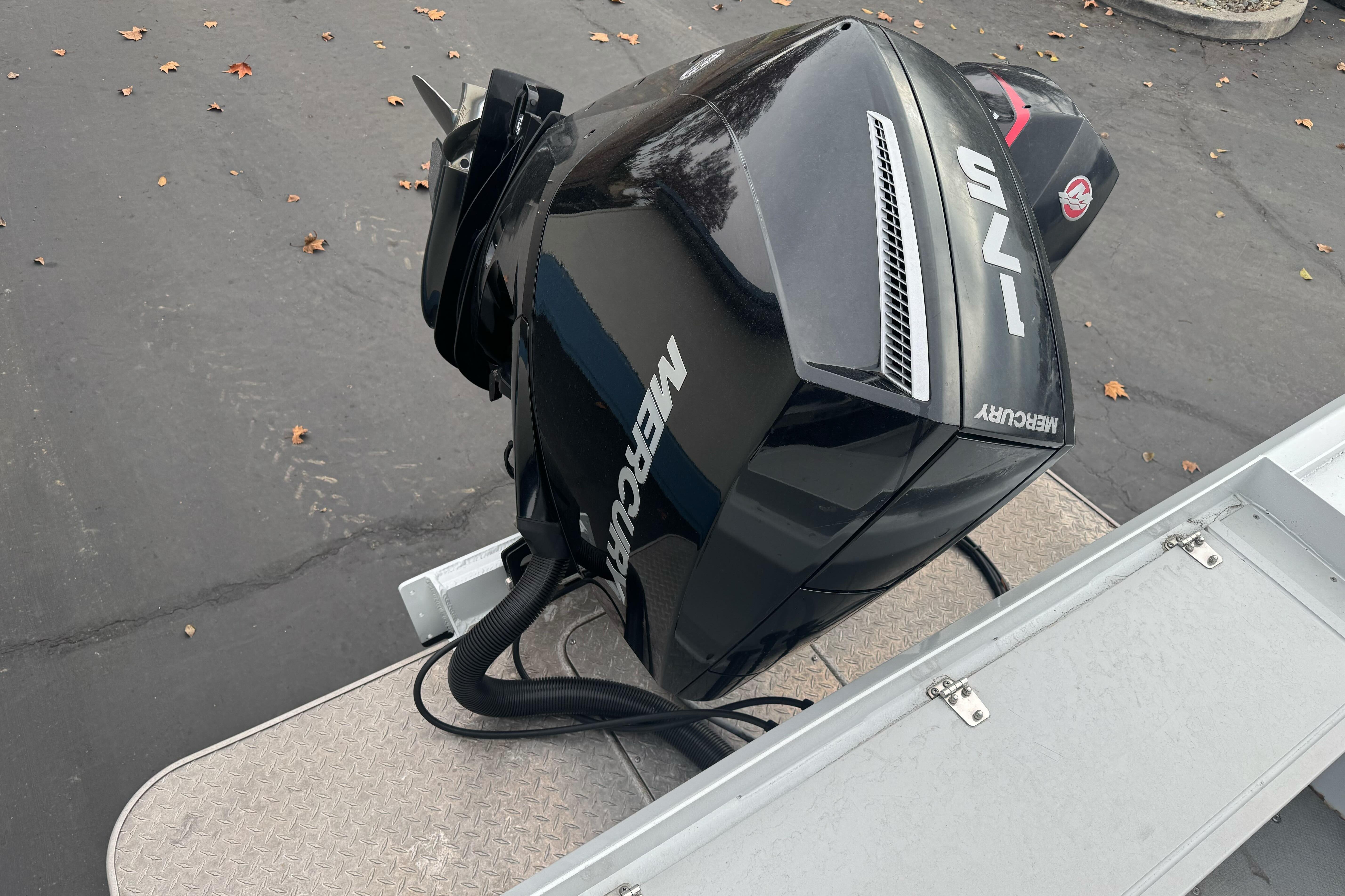 Outboard motor on a 2021 KingFisher 2025 Escape HHT boat, parked on pavement.