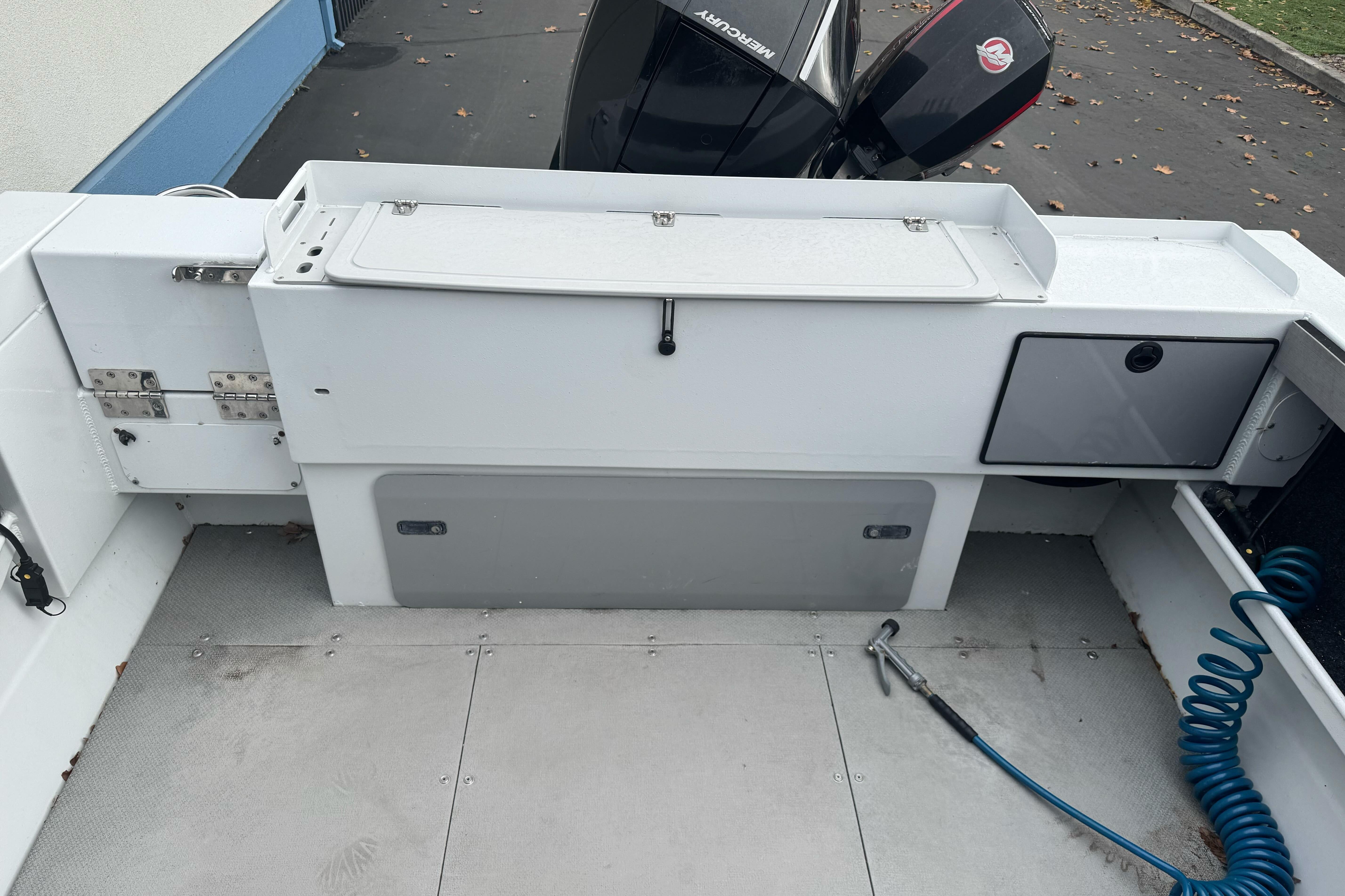 2021 KingFisher 2025 Escape HHT boat interior with storage and Mercury outboard motor.