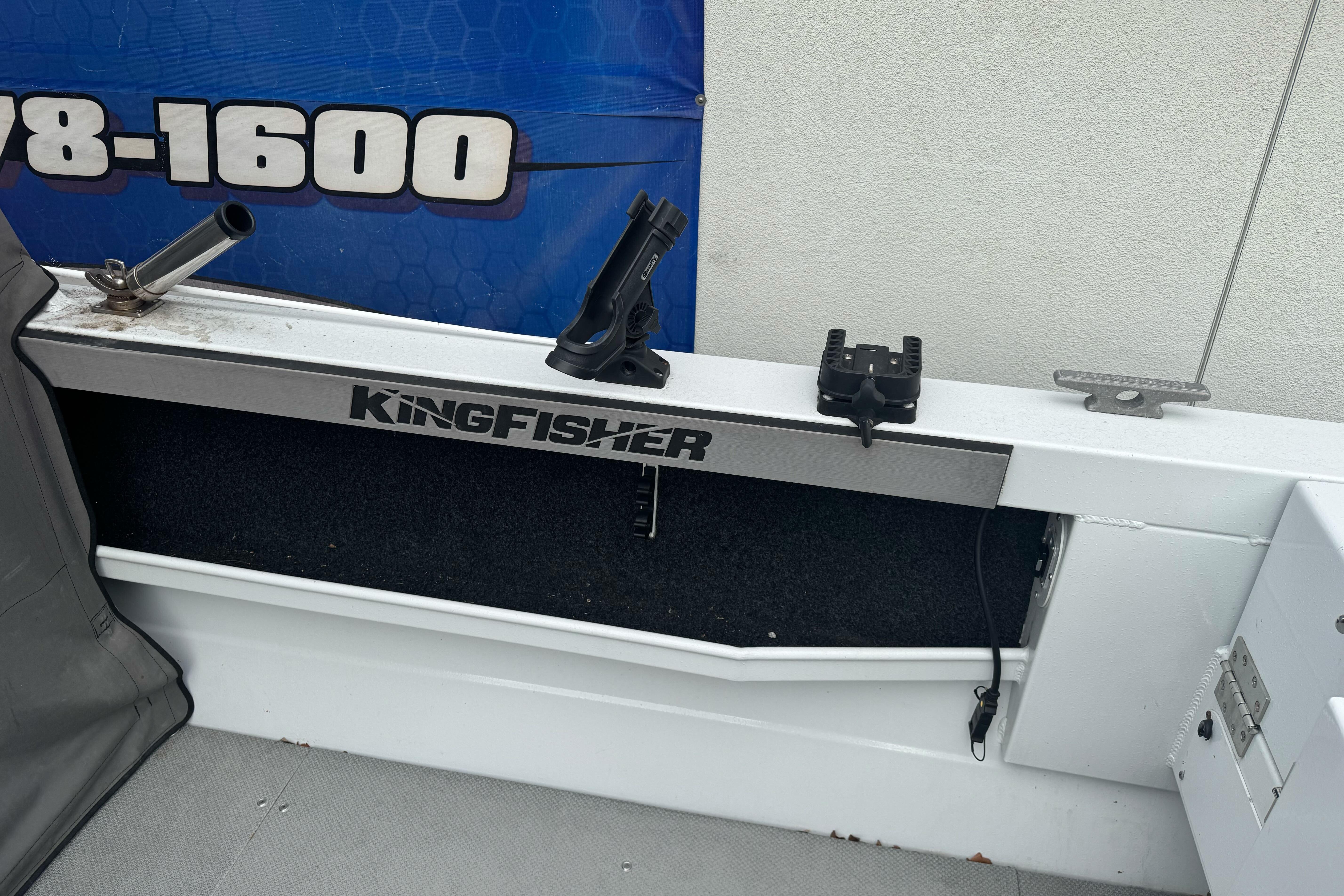 KingFisher 2025 Escape HHT boat interior with rod holders and storage compartment.