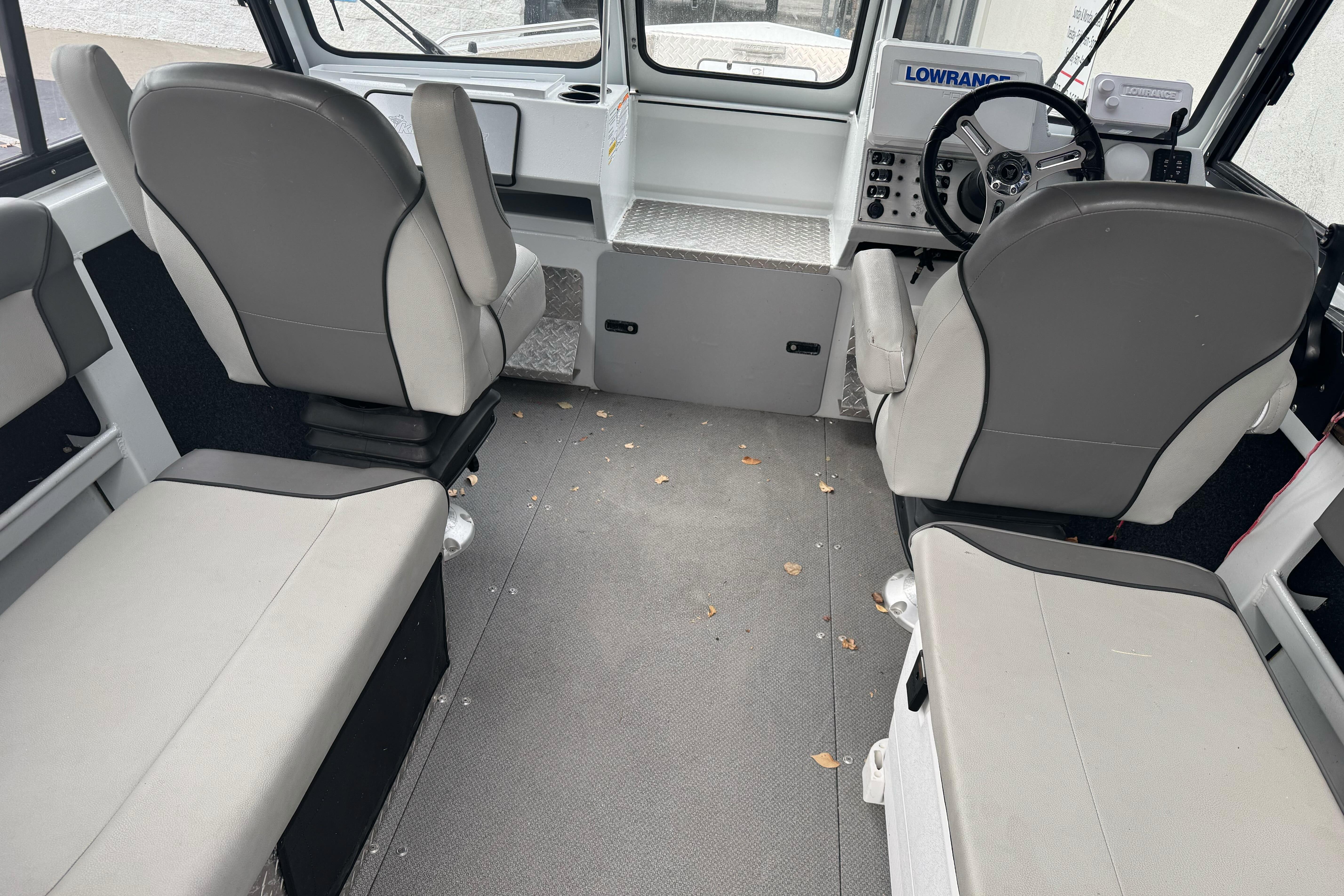 Interior of 2021 KingFisher 2025 Escape HHT boat with seating and steering console.
