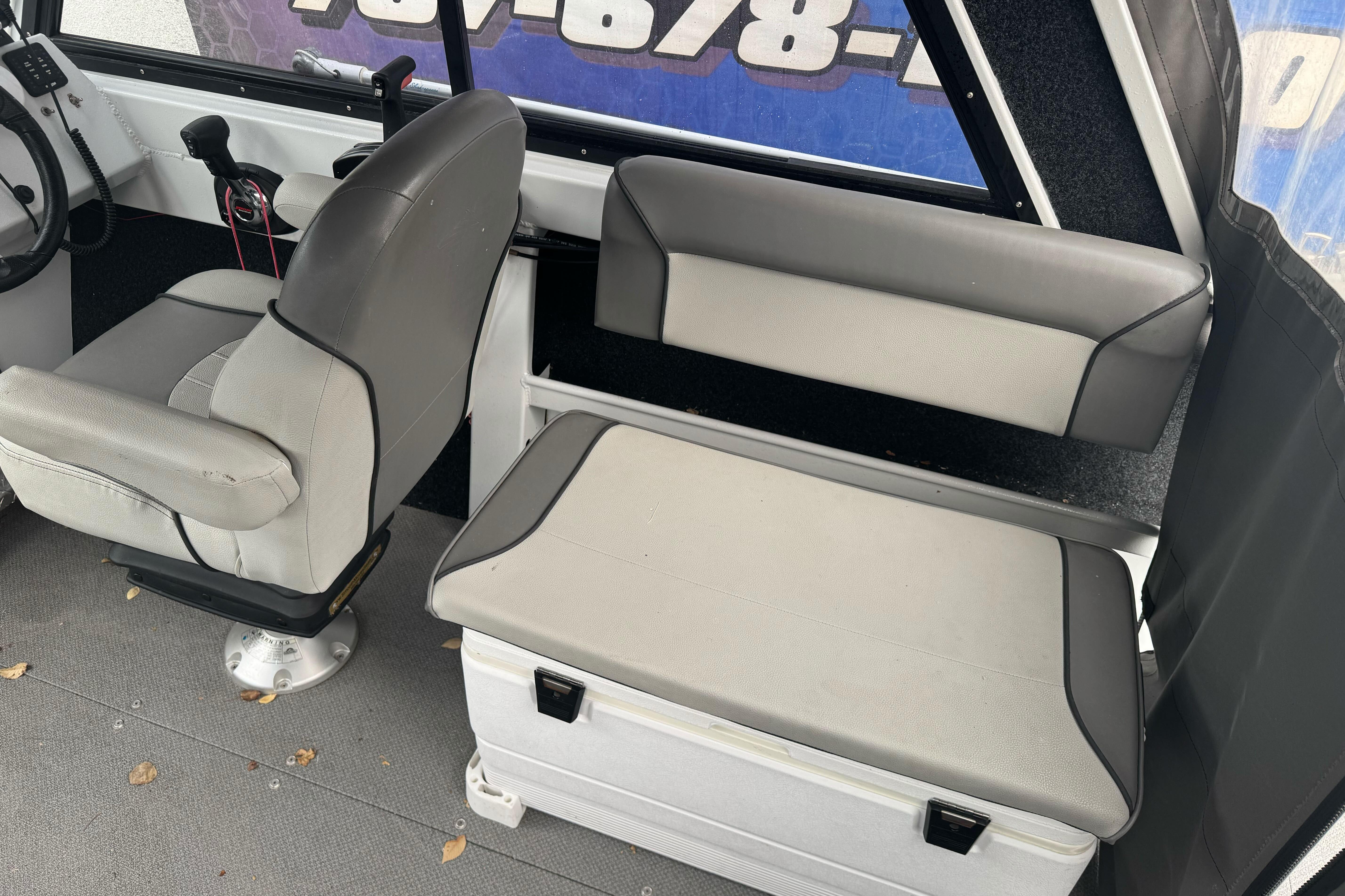 Interior of 2021 KingFisher 2025 Escape HHT boat with gray seating and controls.