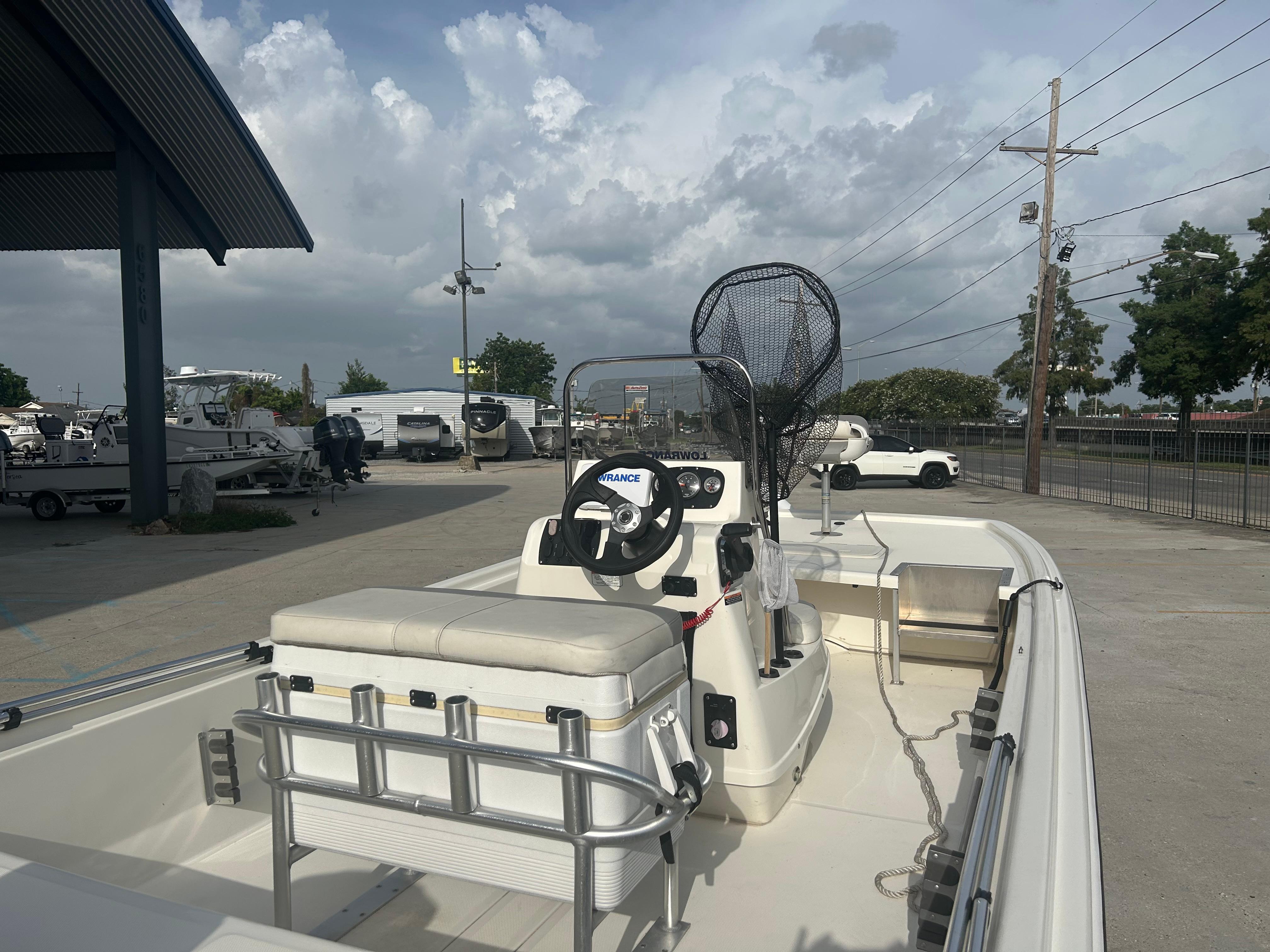 2021 Mako Pro Skiff 19 CC boat with center console and fishing gear, parked outdoors.