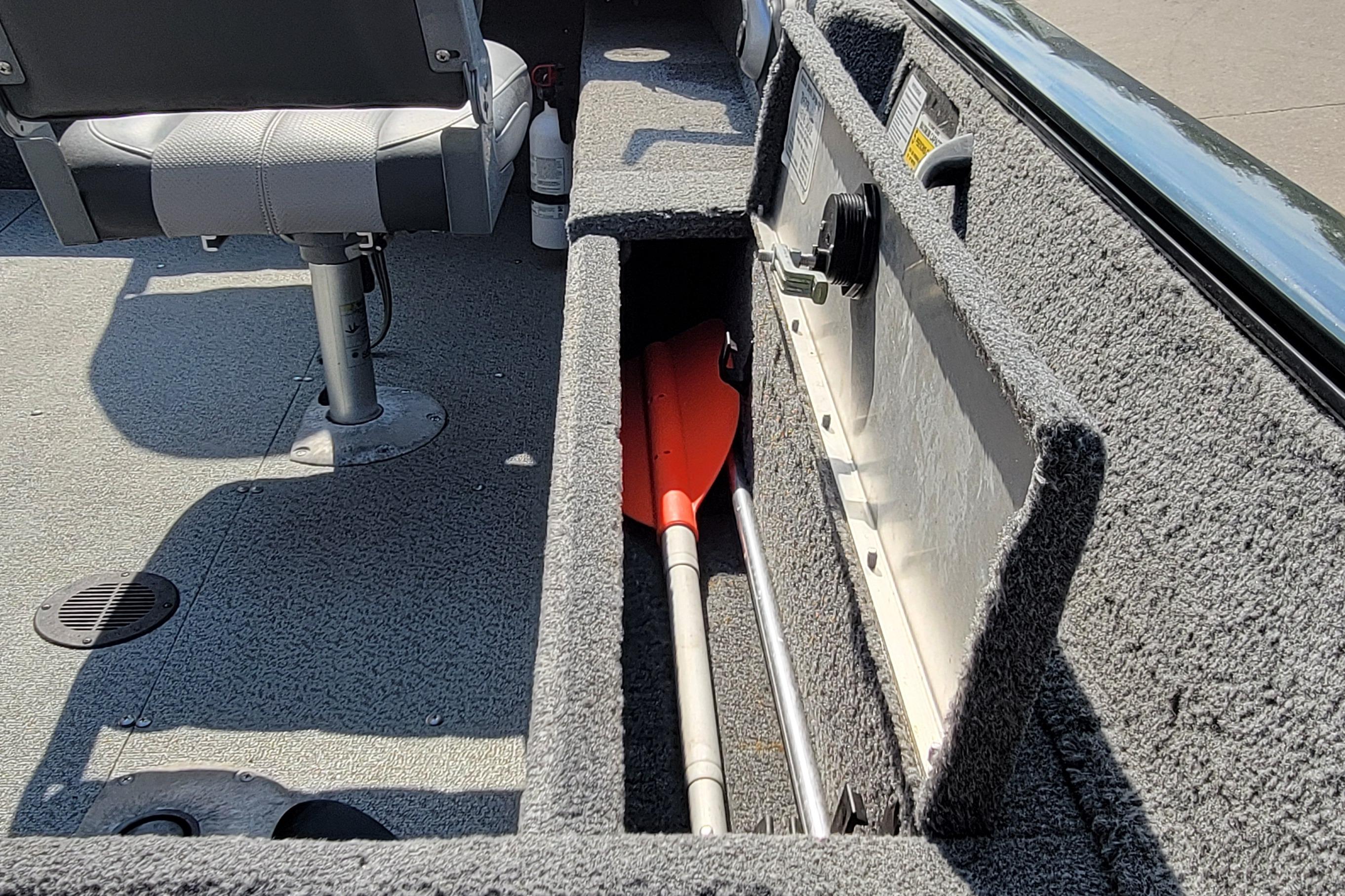 2016 TRACKER MARINE PRO GUIDE V-16 SC boat interior with storage compartment and paddle.