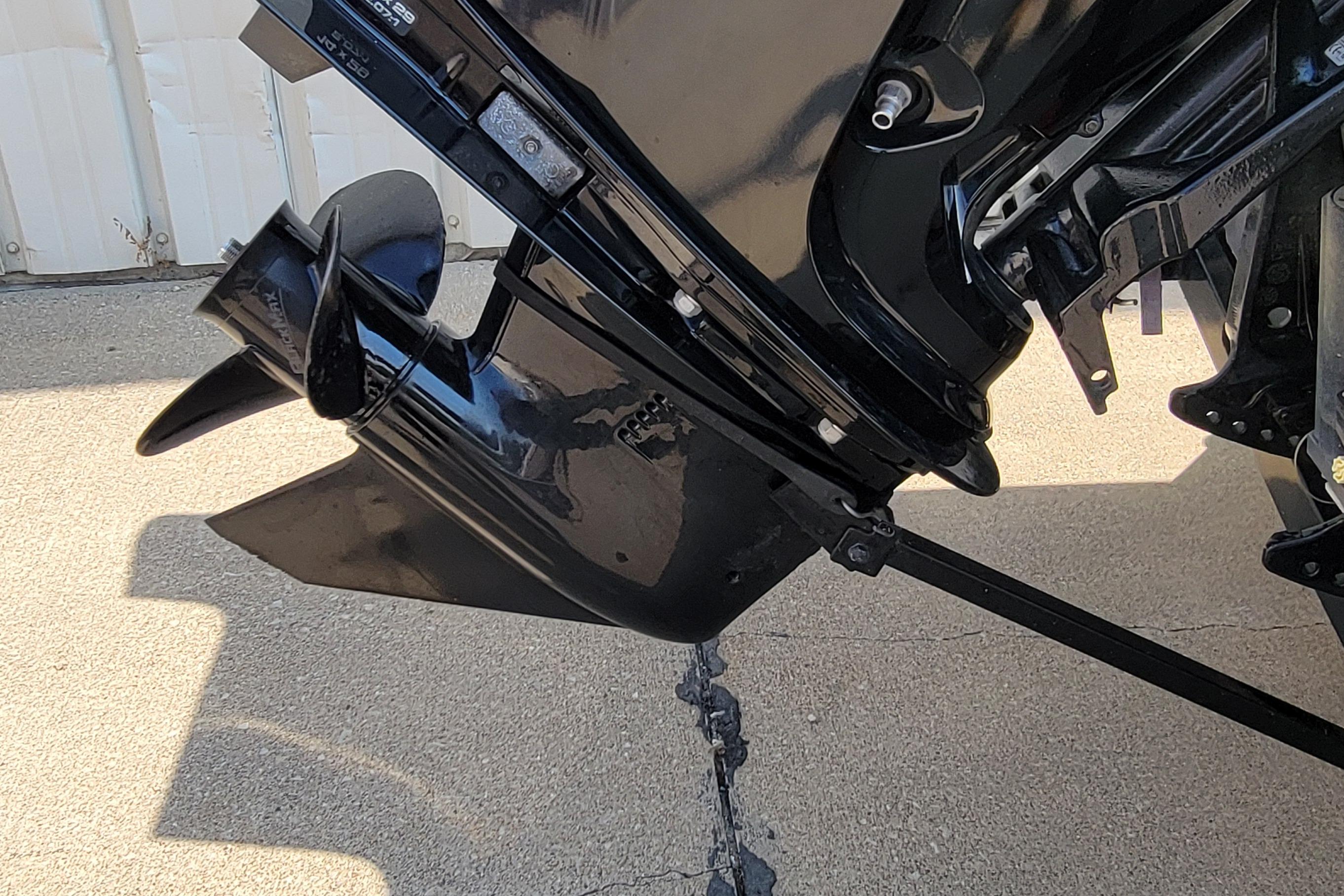 2016 Tracker boat motor propeller on concrete surface, close-up view.
