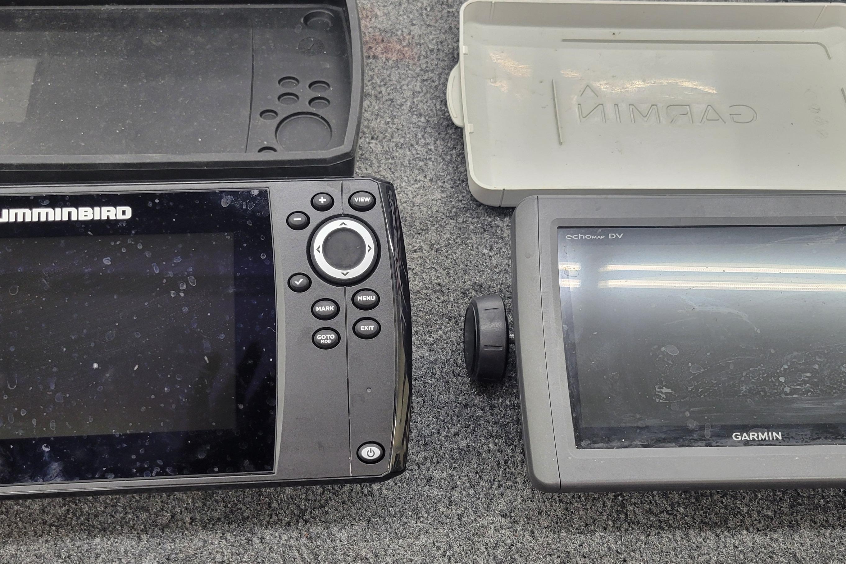 Two fish finders, Humminbird and Garmin, on a gray surface, 2016 Tracker model.