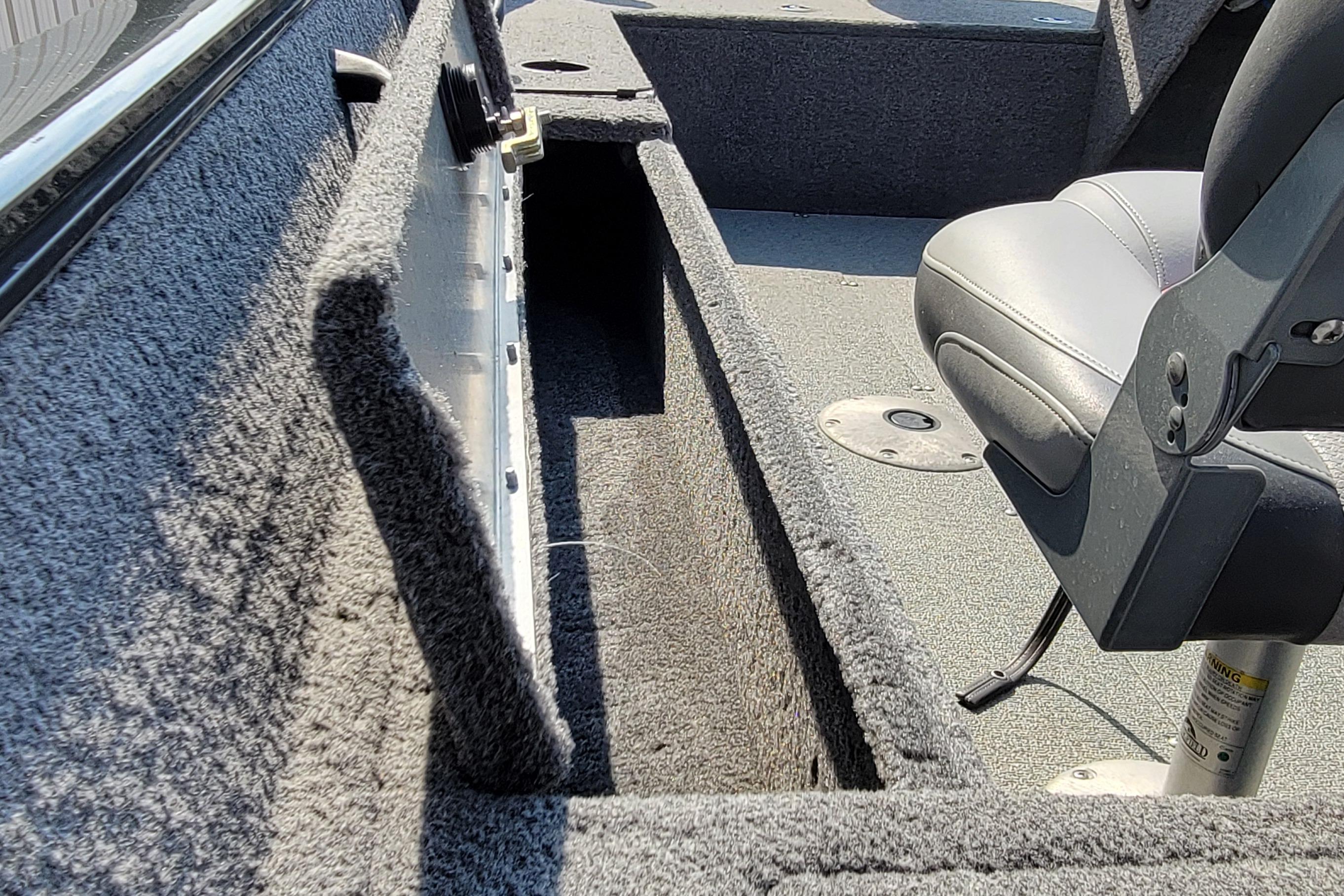 Interior of a 2016 Tracker boat showing storage compartment and seating.