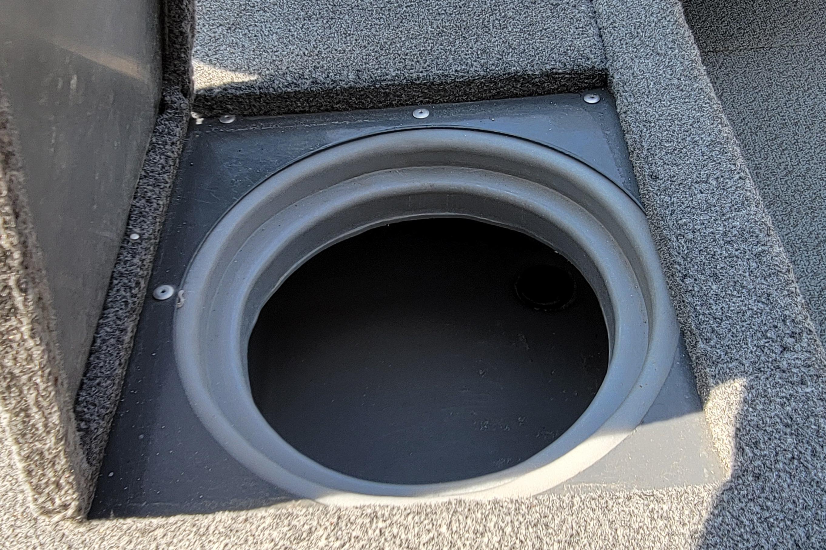 2016 Tracker boat livewell compartment with open lid, featuring gray interior and carpeted edges.