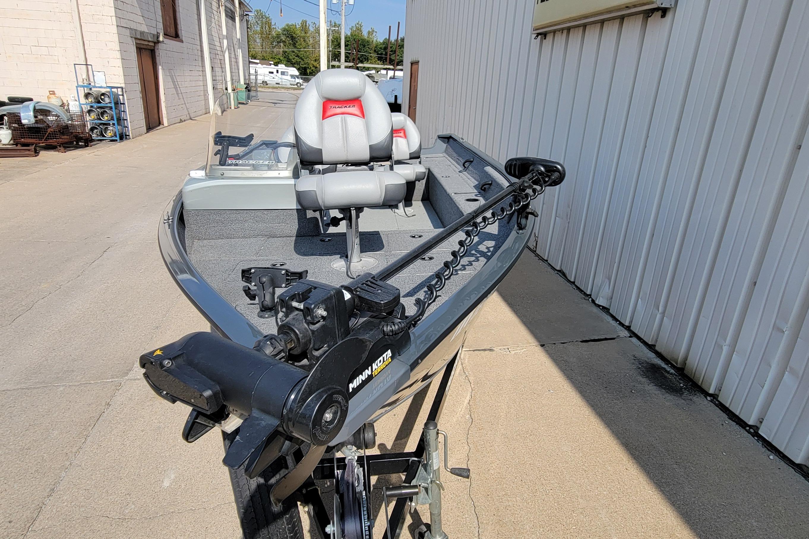 2016 Tracker boat with Minn Kota motor, parked outdoors near a building.