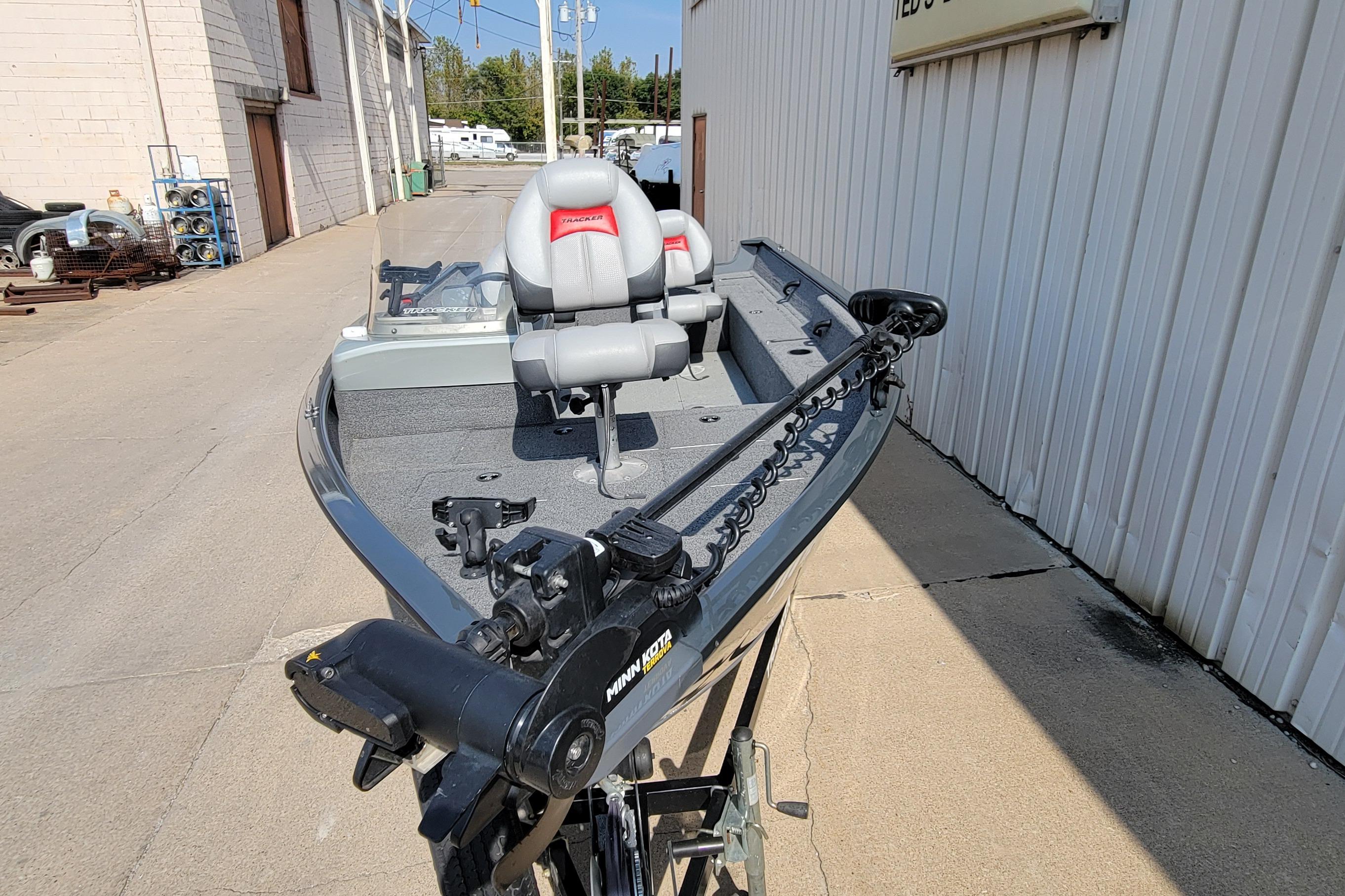 2016 Tracker boat with Minn Kota trolling motor, parked outside a building.