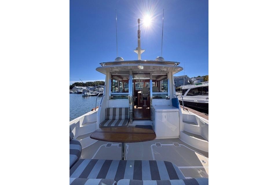 2012 Sabre 42 Salon Express yacht with sunlit deck and striped seating.