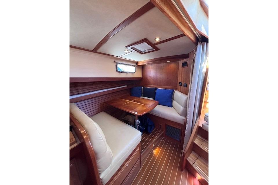 2012 Sabre 42 Salon Express interior with wooden dining area and cushioned seating.