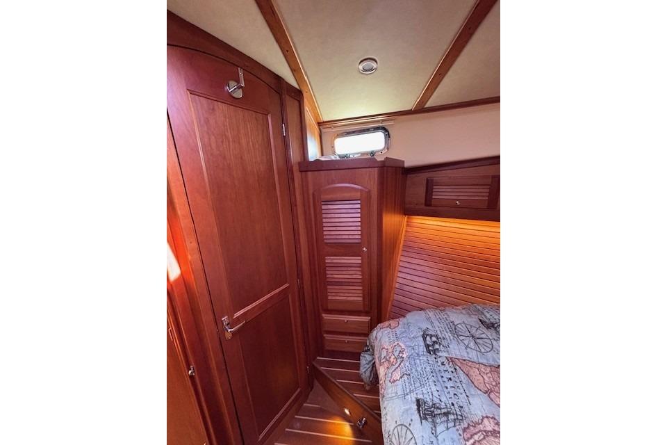 Interior cabin of 2012 Sabre 42 Salon Express with wooden finishes and nautical-themed bedding.