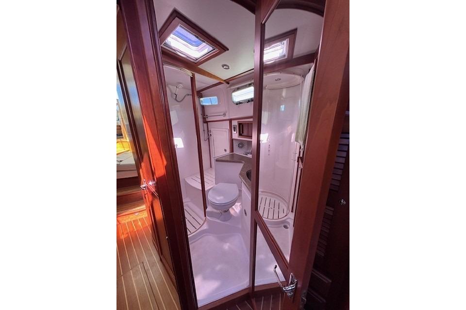 2012 Sabre 42 Salon Express bathroom with shower, toilet, and wooden accents.